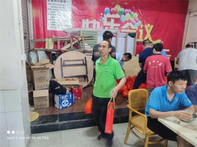 聚餐後同事們提著公司（sī）發放的月餅和柚子回家