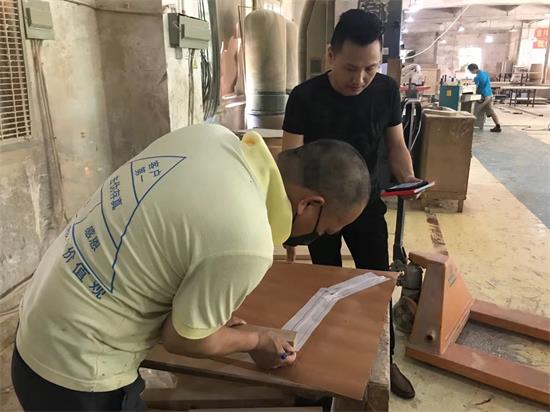 設(shè)計師看著產品工程師做首件家具前,按著1:1做出來的(de)模板,核對每一處比例。